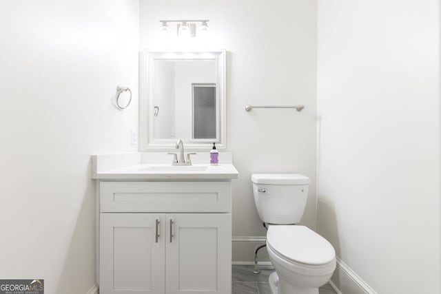 bathroom with tile patterned flooring, vanity, and toilet