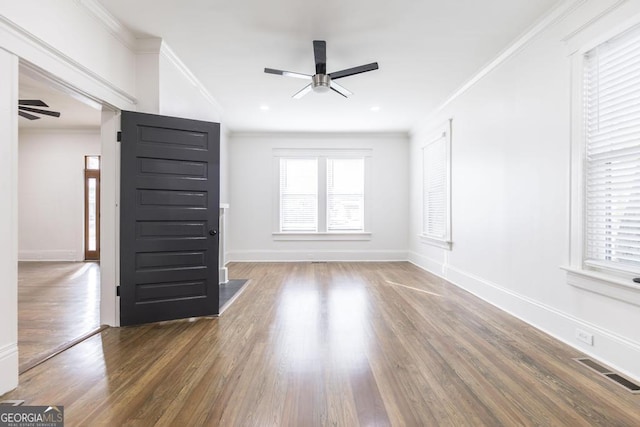 unfurnished living room with ceiling fan, dark wood-type flooring, and crown molding