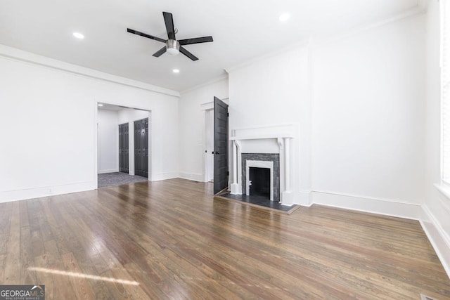 unfurnished living room with a fireplace, ceiling fan, crown molding, and hardwood / wood-style flooring