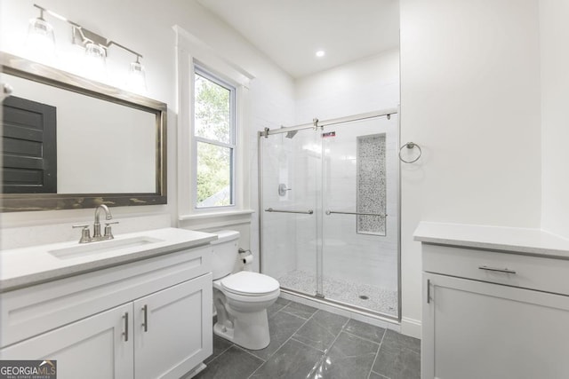 bathroom featuring toilet, a shower with door, and vanity