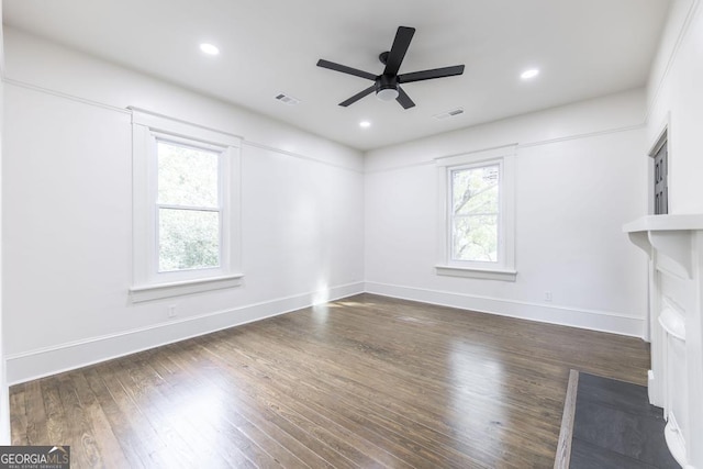 unfurnished living room with ceiling fan, plenty of natural light, and dark hardwood / wood-style floors