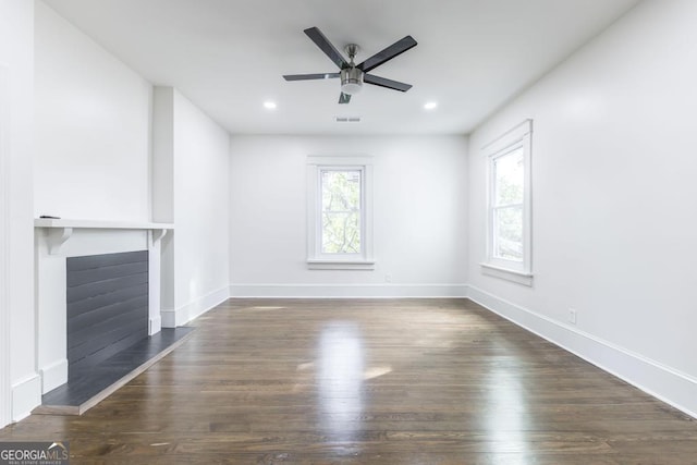 unfurnished living room featuring ceiling fan, plenty of natural light, and dark hardwood / wood-style floors