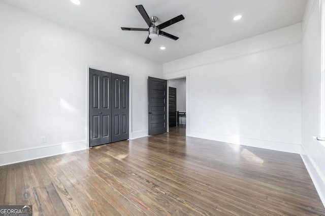 unfurnished bedroom featuring ceiling fan and dark hardwood / wood-style floors