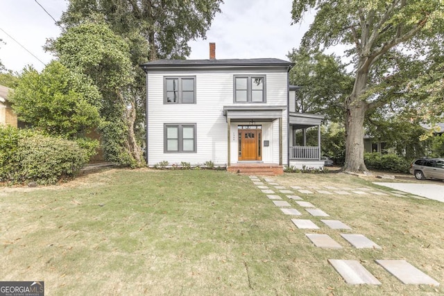 view of property with covered porch and a front yard