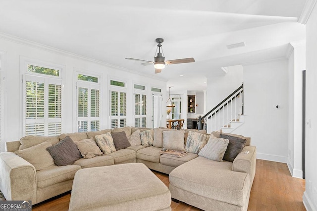 living room featuring ceiling fan, crown molding, and light hardwood / wood-style flooring