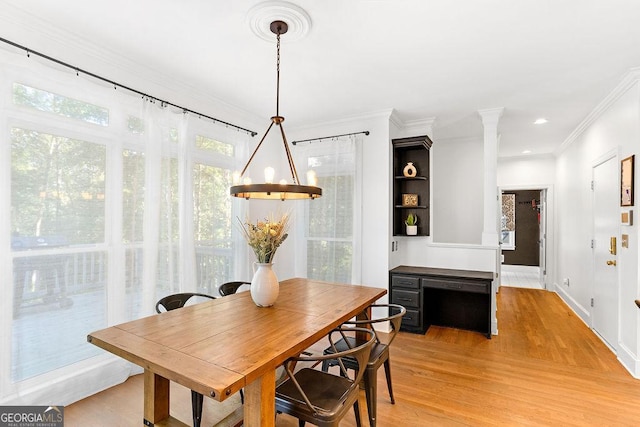 dining room with crown molding and light hardwood / wood-style flooring