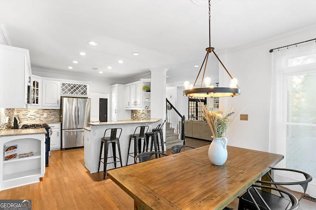 dining room featuring ornamental molding, light hardwood / wood-style flooring, and a chandelier