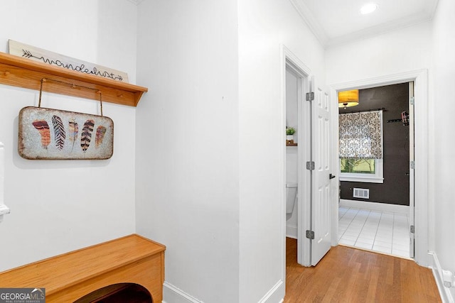 hall featuring hardwood / wood-style flooring and crown molding