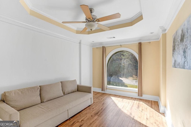 living room with ornamental molding and a tray ceiling