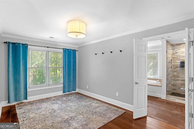 empty room with hardwood / wood-style flooring and crown molding