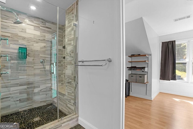 bathroom featuring wood-type flooring and a shower with shower door