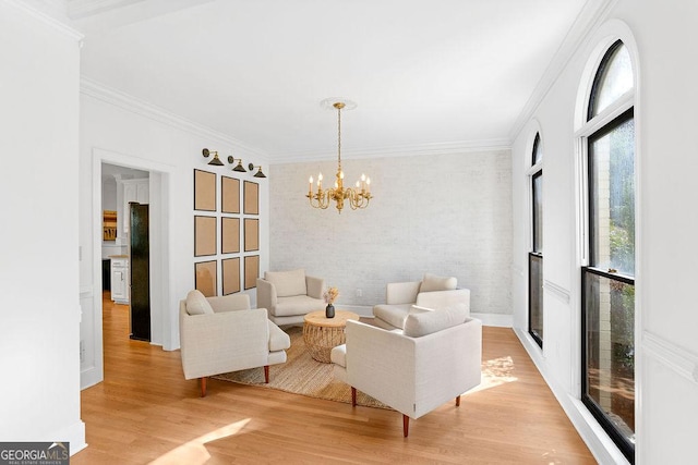 living room featuring light hardwood / wood-style flooring, an inviting chandelier, and crown molding