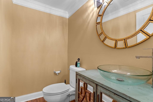 bathroom with ornamental molding, vanity, and toilet