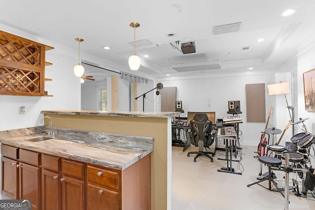 kitchen with light stone countertops, decorative light fixtures, a raised ceiling, crown molding, and sink