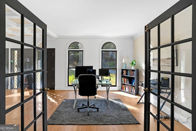 home office with french doors, light wood-type flooring, and crown molding