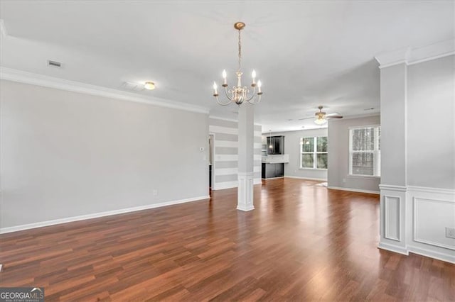 unfurnished living room featuring dark wood-type flooring, ceiling fan with notable chandelier, ornamental molding, and ornate columns