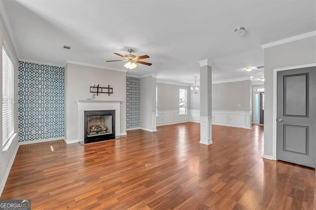 unfurnished living room featuring ceiling fan, ornamental molding, and decorative columns