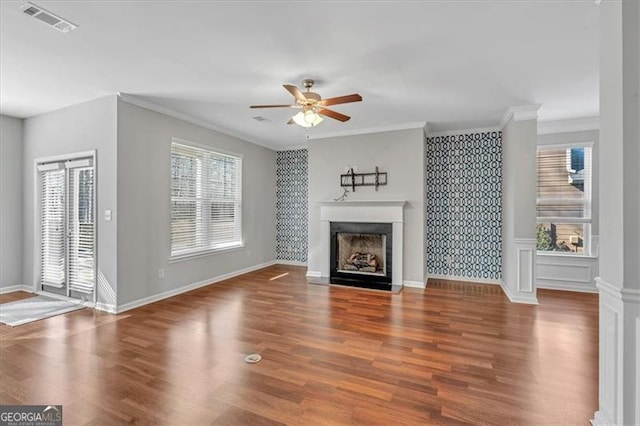 unfurnished living room with ceiling fan, wood-type flooring, and crown molding