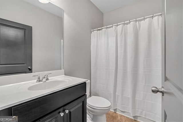 bathroom featuring toilet, vanity, and tile patterned flooring