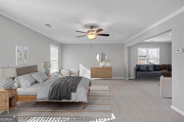 carpeted bedroom with ceiling fan and ornamental molding