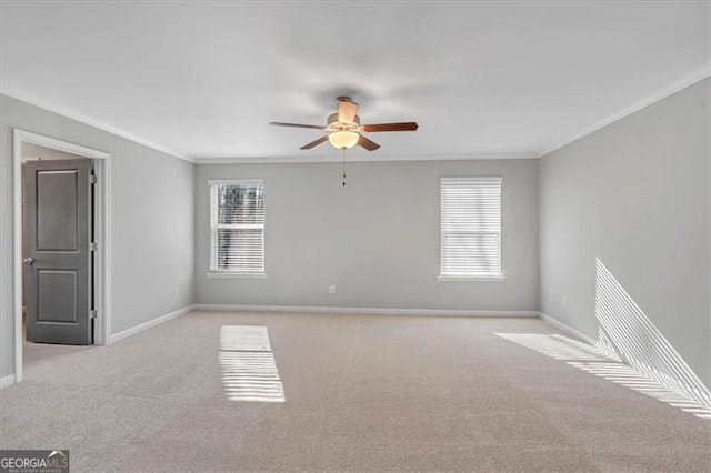 carpeted spare room with ceiling fan and ornamental molding