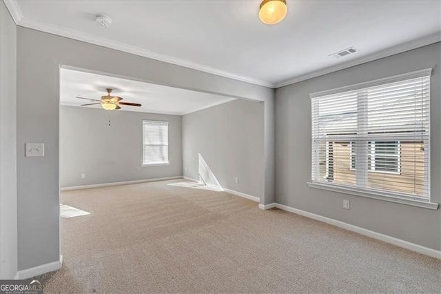 unfurnished room featuring ceiling fan, light colored carpet, and crown molding