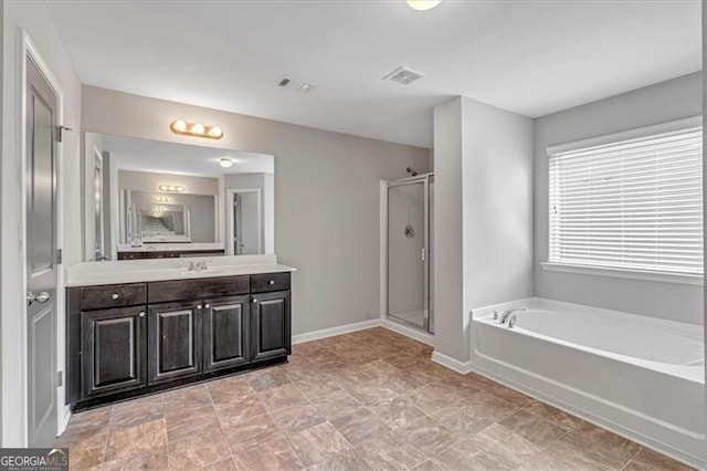 bathroom with vanity and shower with separate bathtub