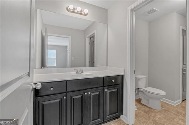 bathroom featuring toilet, tile patterned flooring, and vanity