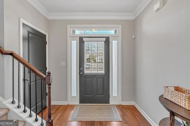 foyer entrance featuring crown molding and light hardwood / wood-style floors