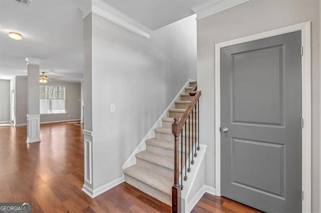 stairs featuring ceiling fan, crown molding, wood-type flooring, and decorative columns