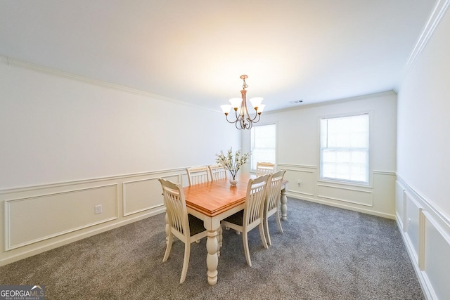 carpeted dining room featuring an inviting chandelier and ornamental molding