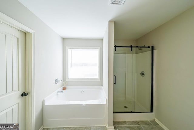 bathroom featuring tile patterned flooring and separate shower and tub