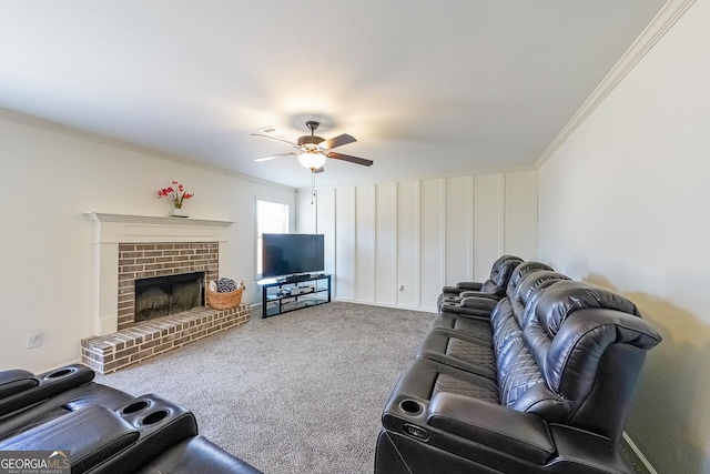 carpeted living room featuring ceiling fan, crown molding, and a fireplace