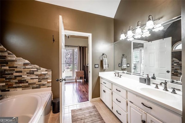 bathroom with a bath, vanity, and tile patterned floors