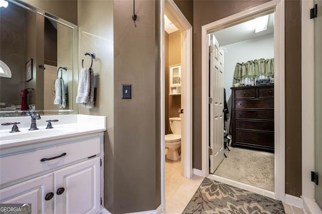 bathroom with toilet, vanity, and tile patterned flooring