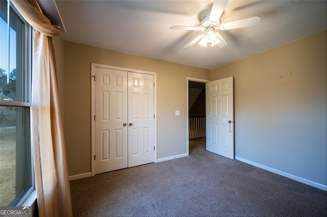 unfurnished bedroom with dark carpet, ceiling fan, and a closet