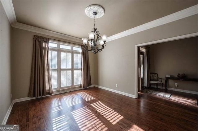 unfurnished room with dark hardwood / wood-style flooring, an inviting chandelier, and ornamental molding