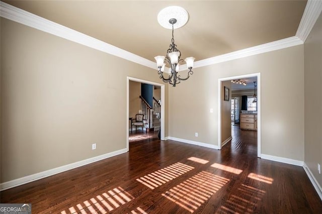 unfurnished dining area featuring dark wood-type flooring, crown molding, and a chandelier