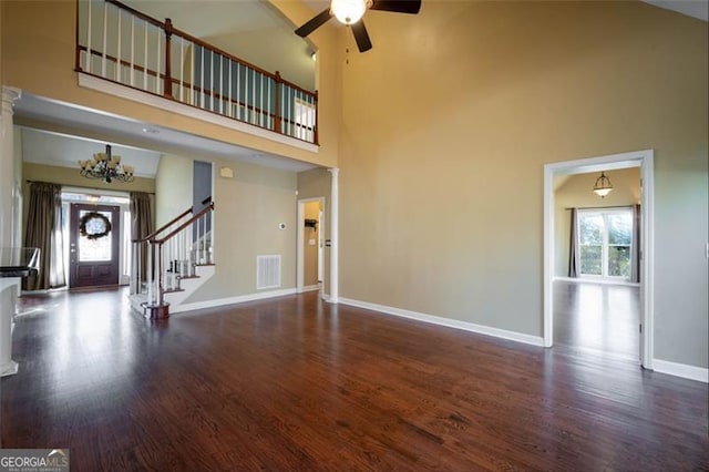 unfurnished living room with a high ceiling, a healthy amount of sunlight, and dark wood-type flooring