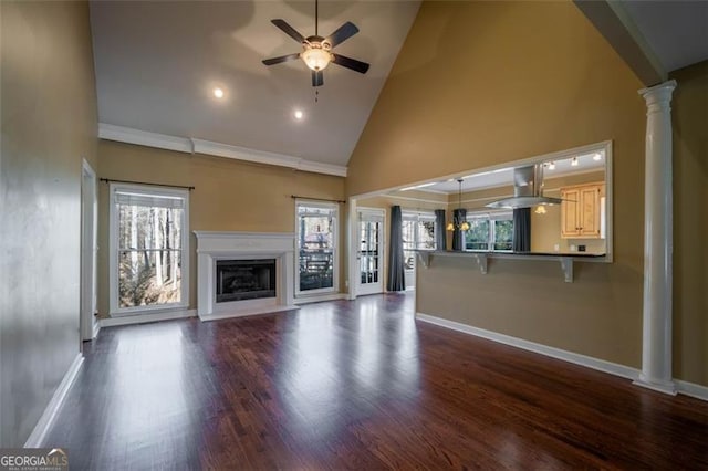 unfurnished living room with ceiling fan, high vaulted ceiling, dark hardwood / wood-style floors, and ornate columns