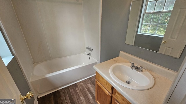 bathroom featuring  shower combination, vanity, and hardwood / wood-style floors