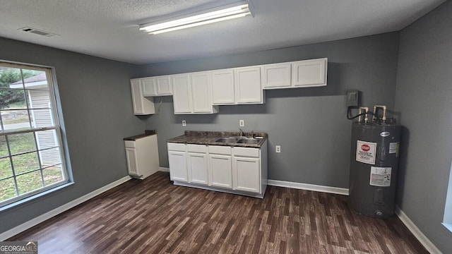 kitchen featuring a textured ceiling, dark hardwood / wood-style floors, electric water heater, white cabinets, and sink