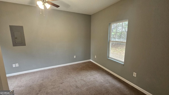 carpeted empty room with electric panel and ceiling fan