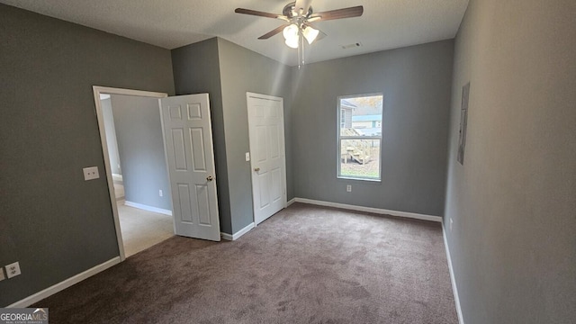 unfurnished bedroom with a textured ceiling, ceiling fan, and light colored carpet