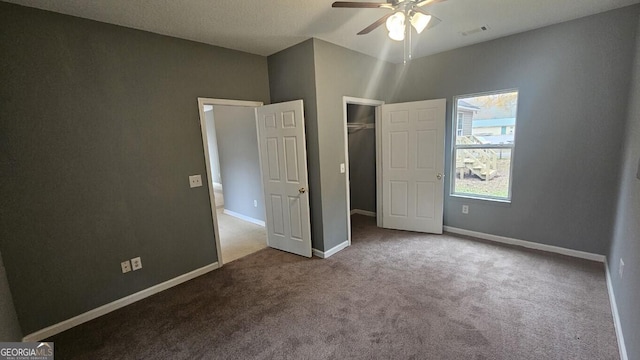 unfurnished bedroom with ceiling fan, a closet, and carpet floors