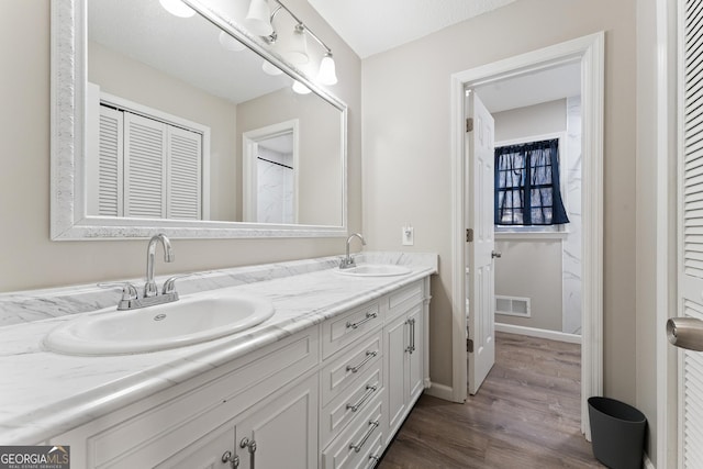 bathroom with hardwood / wood-style flooring, a textured ceiling, and vanity