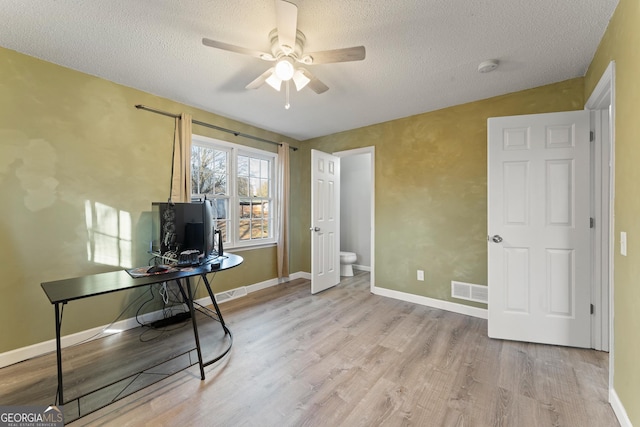 office area featuring lofted ceiling, a textured ceiling, ceiling fan, and light hardwood / wood-style floors