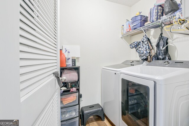 washroom featuring washer and clothes dryer, a textured ceiling, and hardwood / wood-style floors