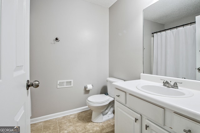 bathroom featuring toilet, vanity, and a textured ceiling