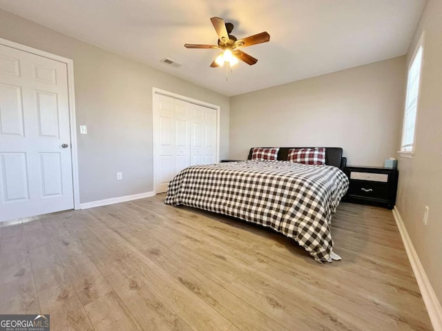 bedroom featuring ceiling fan, light hardwood / wood-style flooring, and a closet